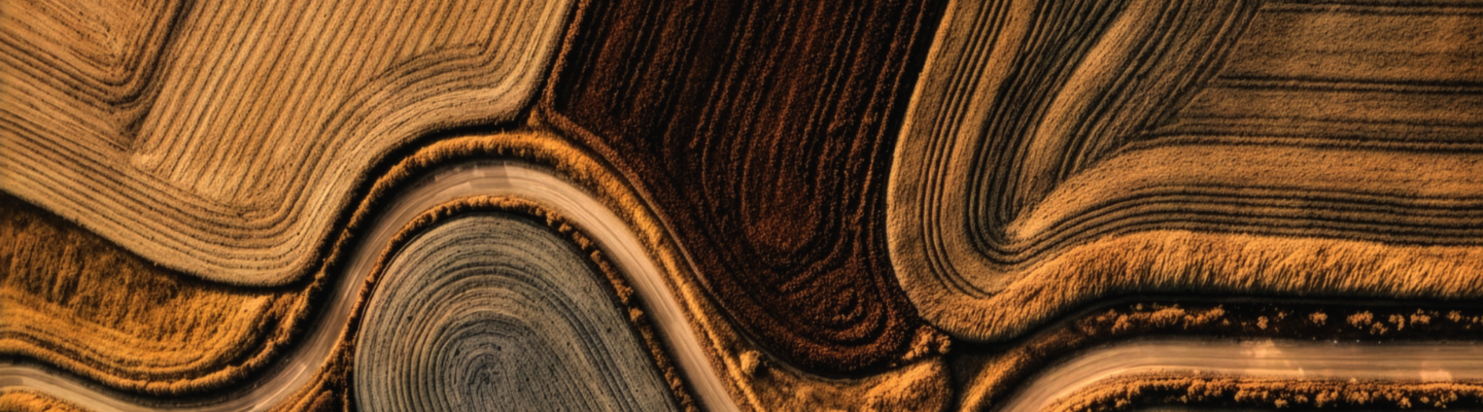 Top shot of sunbaked farmlands image in natural colours resembling the texture of DESSO Arable carpet tiles